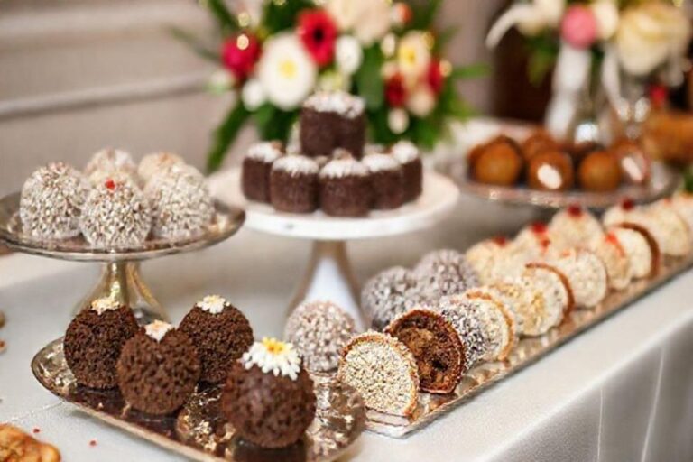 Uma mesa cheia de brigadeiros gourmet prontos para serem adorados.