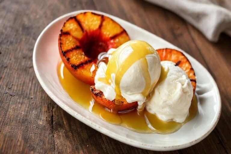 Sobremesa de pêssego grelhado com sorvete.