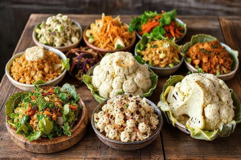 Várias receitas de couve-flor dispostas de forma apetitosa em uma mesa rústica.