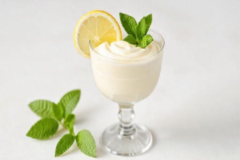 Uma mousse de limão apresentada em um copo de sobremesa.