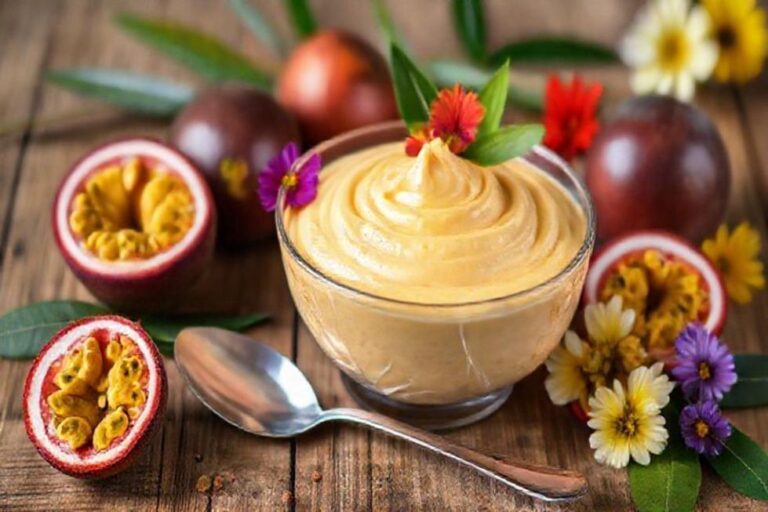Delicious bowl of passion fruit mousse decorated with edible flowers.